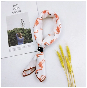 Detail of silk scarf with orange geometric print and black leather buckle on magazine