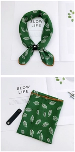 Detail of dark green neck scarf with white leaf patterns and black leather buckle strap