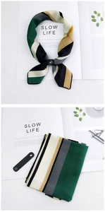 Detail of striped silk-feel scarf with retro geometric patterns and leather ring buckle