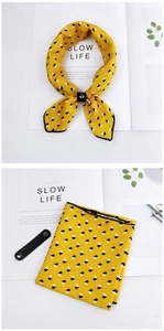 Detail of yellow silk scarf with geometric cubes and black leather ring buckle