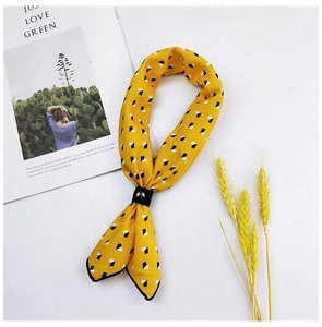 Detail of yellow cotton linen scarf with geometric pattern and black decorative buckle