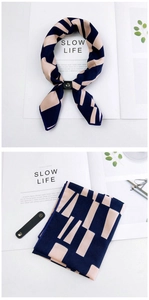 Detail of navy and beige geometric scarf with black leather buckle on white background
