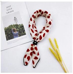 Detail of ivory silk scarf with red hearts, featuring a leather ring and metal buckle