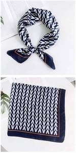 Détail du foulard carré en soie à motifs géométriques bleu marine et blanc avec bord orange