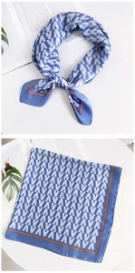 Détail d'un foulard carré en soie à motif V bleu avec une bordure orange vif