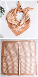 Détail du foulard carré orange avec motif en V blanc et finition satinée élégante
