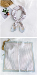 Détail d'un foulard en soie avec motif de lettres VAVA et bordure jaune