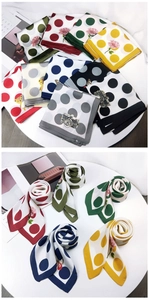 Close-up of assorted polka dot silk scarves with floral patterns and rolled details