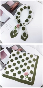 Detailed view of white silk square scarf with green polka dots and pink floral pattern