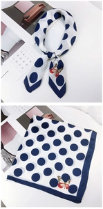 Close-up of polka dot silk scarf featuring vivid butterfly print and hemmed edges