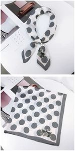 Close-up of white silk square scarf with gray polka dots and vintage camera illustration