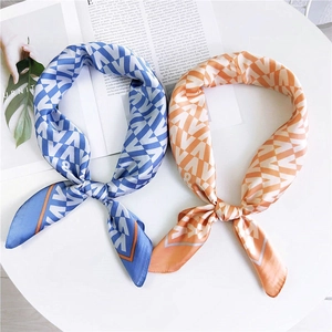Carré de soie soyeux avec motif en V géométrique en bleu et orange sur fond blanc