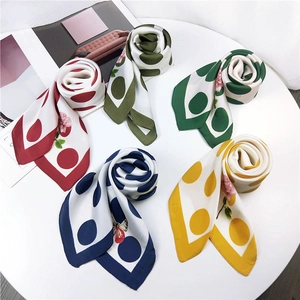 Silk-like polka dot square scarves in five colors with floral patterns on a white table