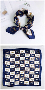 Detail of equestrian print silk scarf in navy and gold featuring horse motifs