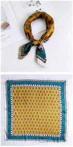 Detail view of mustard yellow silk scarf featuring intricate green paisley patterns