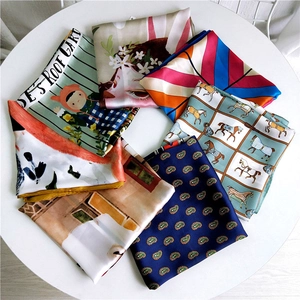 Various colorful cartoon print silk square scarves arranged in a circular layout
