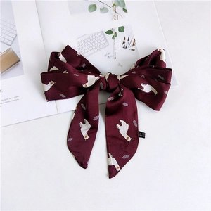 Detail of burgundy narrow satin scarf with white alpaca print and material label