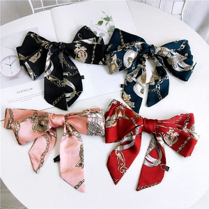 Detail of four retro style silk satin bow hair ribbons with gold chain patterns