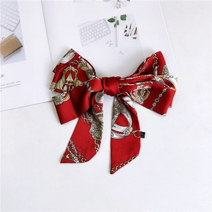 Detail of red satin bow headband with vintage chain pattern and quality labels
