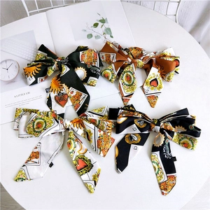 Close-up of retro card print satin hair ties with large bows on a white table