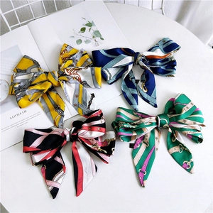 Detail of colorful silk bow hair clips with vintage chain patterns and long streamers