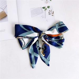 Detail of a thin silk scarf with vintage equestrian horse harness patterns and navy trim