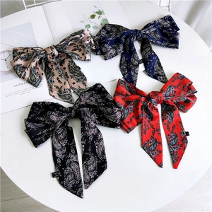 Set of four satin bow hair ribbons with paisley prints in pink, navy, black and red
