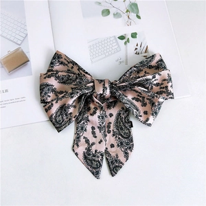 Detail of pink paisley satin ribbon bow with long tails on lifestyle magazine