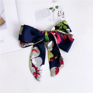 Detail of dark blue floral satin hair bow clip with smooth texture on magazine