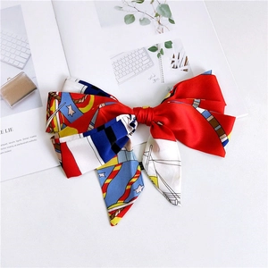 Detail of red satin skinny scarf with nautical print used as a large decorative bow tie