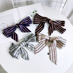 Macro detail of striped silk bow hair scarves in navy, black, grey and pink colors