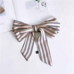 Detail of pink striped 100% polyester narrow silk scarf with bow tie and laundry label