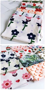 Détail de foulards aux imprimés floraux et fruités avec coutures de finition précises