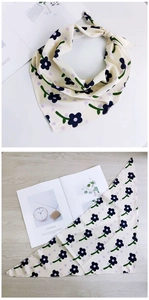 Détail d'un foulard triangle beige avec motifs floraux bleus et pois violets