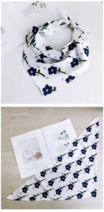 Vue détaillée d'un foulard triangle floral avec imprimé fleurs violettes et bords cousus