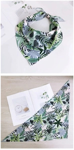 Gros plan détaillé d'un foulard triangle floral avec motifs de feuilles vertes et bordures