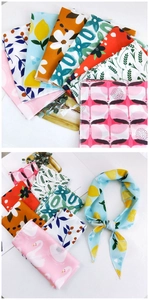 Vue détaillée de foulards en soie à fleurs avec motifs citron, flamant et XOXO