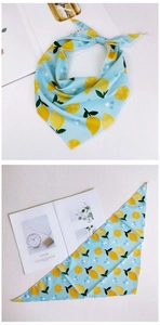 Détail d'un foulard triangulaire floral avec motifs citrons sur fond bleu