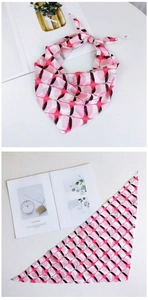 Vue détaillée du foulard triangle rose à fleurs avec imprimé oiseaux et texture satinée