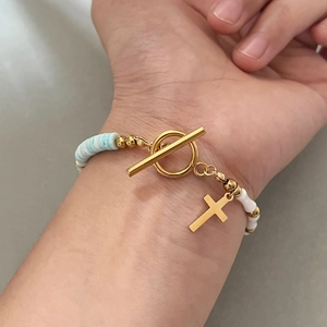 Bamboo style shell bead bracelet with golden cross pendant and OT toggle clasp
