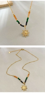 Detailed macro view of 18K gold sun pendant with colorful faceted beads on a vintage chain