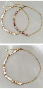 Detail of bohemian necklace with colorful disc beads and golden paperclip chain
