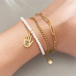 Three-piece layered gold bracelet set featuring a Hamsa hand charm and classic link chains