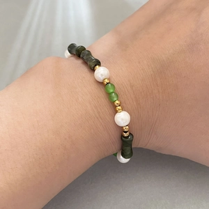 Handmade bamboo jade bead bracelet with white pearls and gold accents on wrist
