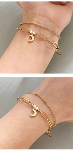 Gros plan du bracelet double rang doré avec pendentif lune et perles blanches