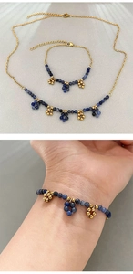 Detail von blauem Sodalith-Perlenhalsketten und Armband-Set mit goldenen Blumenanhängern