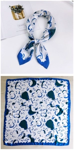 Detailed view of square silk scarf with abstract blue patterns and wavy blue borders