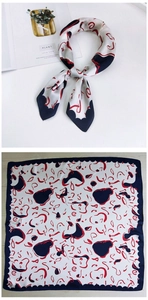Close-up of a 70cm satin square scarf with red and navy abstract prints and wavy edges