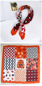 Detail of 70cm square scarf featuring tropical leaves and geometric orange patterns