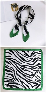 Detail of zebra print square scarf with green border shown folded and flat